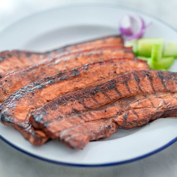inihaw na liempo with a side of fresh cucumbers and onion