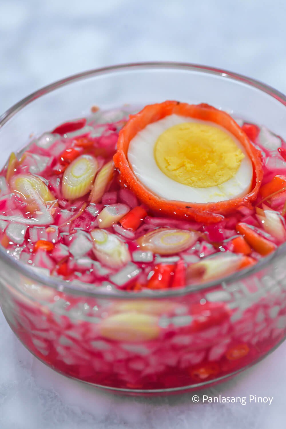 Coated fried egg dipped in spicy vinegar