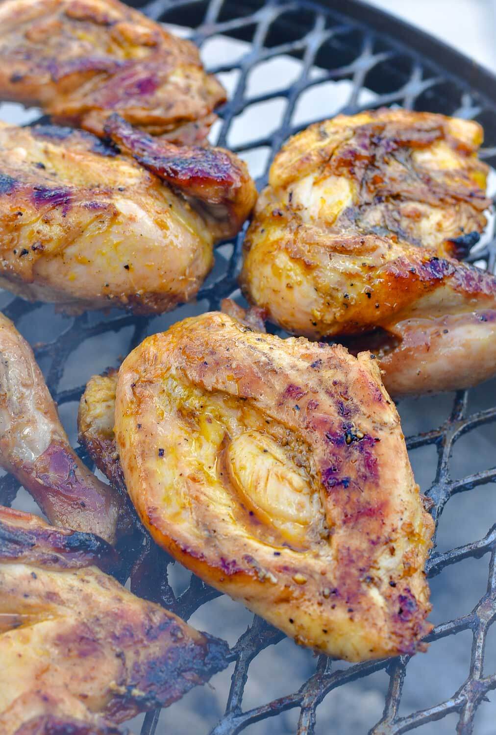 Grilling chicken over a charcoal grill