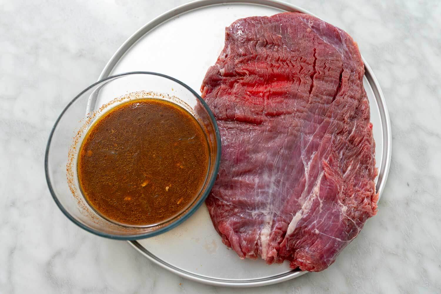 Flank Steak marinade and flank steak side by side