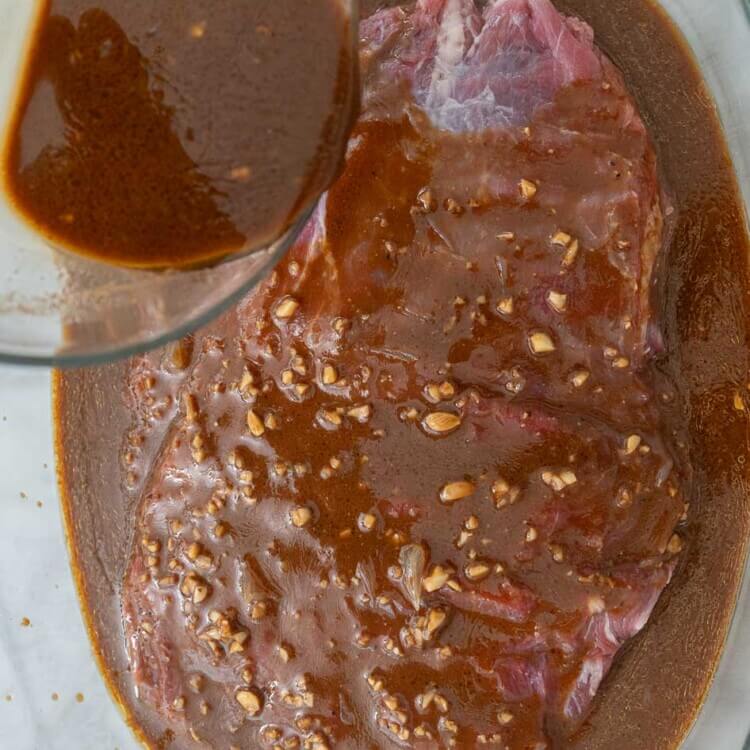Marinade being poured over flank steak