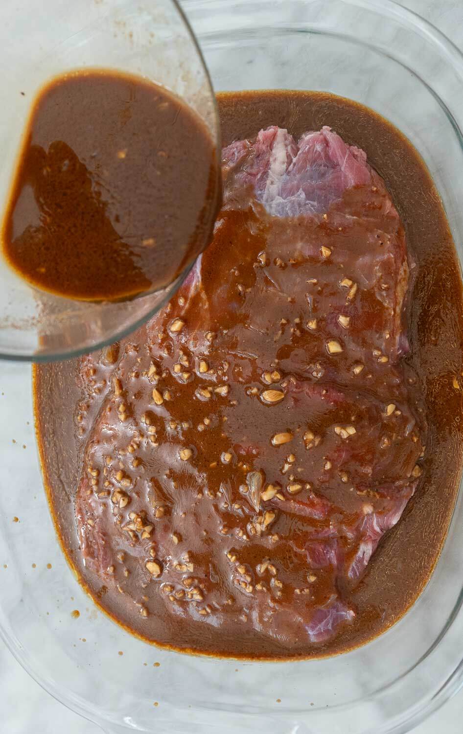 Marinade being poured over flank steak