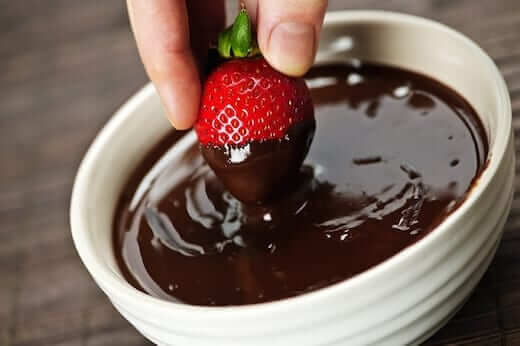 dipping a strawberry in chocolate