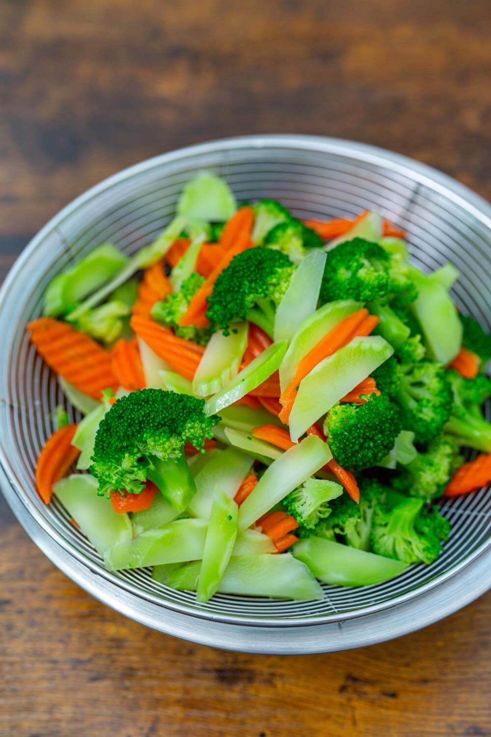 Blanched broccoli and carrot on a strainer