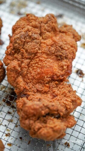 Crispy fried chicken thigh over a rack